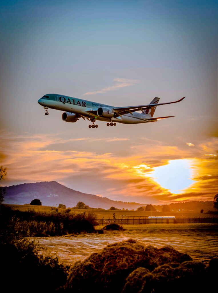 pexels-photo-1443894-1443894 A passenger airplane flying over a scenic landscape at sunset, capturing the aviation spirit.